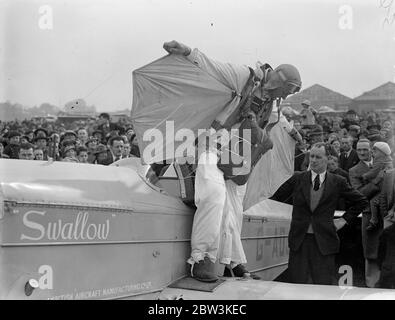 Birdman fliegt mit Flügeln auf Hanworth zur Erde. Clam Sohn, ein junger Amerikaner aus, Lansing Michigan, gab seine erste Ausstellung von "Vogel" Flug in großbritannien in Hanworth Air Park, Feltham, Middlesex. Einen Flügelanzug und eine Flosse an sich ziehen Sohn flog aus einer Höhe von etwa 10, 000 Fuß auf die Erde wie eine riesige Möwe. Er faltete seine Flügel und zog die Schnur eines Fallschirms, als er innerhalb von 1, 000 Fuß des Bodens, Foto zeigt Clem Sohn demonstriert die Wirkung seiner Flügel, um die Menge vor dem Aufsteigen. Mai 1936 Stockfoto