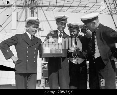 Preistag auf der HMS Worcester, das Trainingsschiff der Thames Nautical Training College in Greenhithe, Kent.Foto zeigt, Cadet R A N Cox Gewinner der King ' s Gold Medal, hält hoch einige seiner vielen Preise. August 1935 Stockfoto