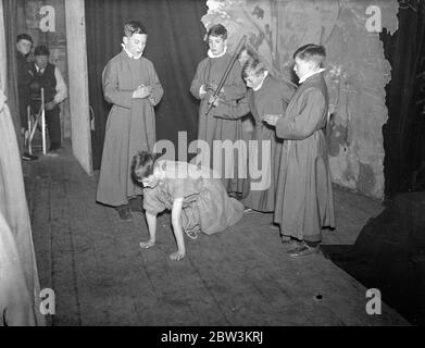 London ' s Boy Bishop peitschte aus dem Amt . London ' s Boy Bishop, Fred Brazier, 12 Jahre alten Chorister von St Mary of the Angels Song School., Highgate, wurde aus dem Amt von seinen Mitschillern in der Entthronungszeremonie in Hampstead peitscht. Er wurde am Nikolaustag inthronisiert. 6. Dezember in der ersten öffentlichen Zeremonie seit der Reformation . Foto zeigt, auf Händen und Knien tragen Sacktuch, der Boy Bishoip (Fred Brazier) ist aus dem Büro gepeitscht. Januar 1936 Stockfoto