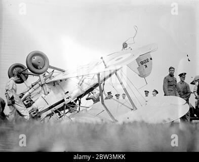 Ein Bristol Bulldog Mk II A von No. 17 Squadron Royal Air Force an der Royal Air Force Station Kenley, Surrey, Registrierung K2216 nach seinem Unfall (links), in dem bei der Landung beim Bremsen das Flugzeug umgedreht. Der Pilot wurde den Absturz lebendig gelassen, aber der Flugzeugschaden war nicht repariert. Der Absturz ereignete sich während der Proben für Empire Air Day, der in diesem Monat stattfinden soll. An diesem Tag werden die RAF-Flugplätze für die öffentliche Inspektion geöffnet. Foto zeigt Bodenpersonal Inspektion der abgestürzten Flugzeug. Ein Pilot an der Nase insepckt den Schaden ( unknow wenn dies der Pilot des Absturzes war Stockfoto