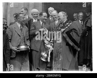 Arsenal Team gegeben Bürgerempfang in Islington . Fahren Sie durch überfüllte Straßen. Das Arsenal-Team, englische Cup-Gewinner, die Durchführung der F A Cup, fuhr durch große Menschenmengen auf die Islington Town Hall, wo sie einen bürgerlichen Empfang gegeben wurden. Das Team wurde vom Bürgermeister, Ratsherr H G Coleman, selbst ein alter Fußballer, im Rathaus empfangen. Foto zeigt, Alex James, der Arsenal Kapitän, wird vom Bürgermeister von Islington empfangen, Ratsmitglied H G Coleman, im Rathaus. 28. April 1936 Stockfoto