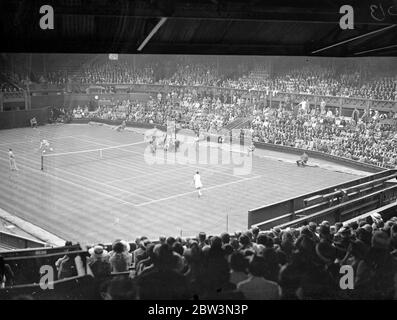 Kay Stammes und Helen Jacobs treffen sich im ersten Wightman Cup Spiel. Trotz der zweifelhaften Wetterbedingungen gab es in Wimbledon ein gutes Publikum, um das Eröffnungsspiel des Wightman Cup-Wettbewerbs zwischen Miss Kay Stammers (Großbritannien) und Miss Helen Jacobs (USA) zu sehen. Foto zeigt, eine allgemeine Ansicht des Spiels. Miss Stammers steht im Vordergrund. 12 Juni 1936 Stockfoto