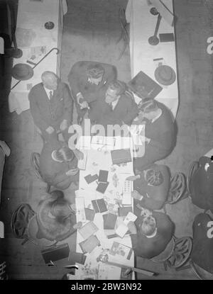 Händler aus aller Welt bei London Briefmarkenbörse . Händler aus allen Teilen der Welt besuchen die neunte Börse der Londoner Briefmarkenhändler, die im Restaurant Holborn eröffnet wurde. Millionen von Briefmarken wechseln während der drei Tage der Börse, Preise werden in vielen Sprachen und Währungen genannt. Foto zeigt, Prüfung Briefmarken an der Börse. 27. April 1936 Stockfoto