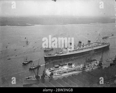 'RMS Queen Mary' segelt von Southampton auf Jungfernfahrt. Angefeuert von einer Viertelmillion Menschen füllen jeden verfügbaren Zoll der Dockes . "Queen Mary", 80, 000 Tonnen Stolz der britischen Handelsmarine, segelte von Southampton auf ihrer Jungfernfahrt nach Amerika. Sie war "über allen gekleidet" mit Fahnen und Hunderte von Booten huschten um sie herum, als sie wegzog. Foto zeigt, eine Luftaufnahme der "RMS Queen Mary", verlassen Southampton Docks. 27 Mai 1936 Stockfoto