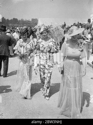 Weißer Sonnenschirm Und Ungewöhnliche Hut Mode Bei Ascot. Ascot, auf Royal Hunt Cup Tag, mit noch besseren Wetterbedingungen als auf der Eröffnung bevorzugt, sah eine noch größere Vielfalt an schönen Mode. Foto zeigt: EIN auffallend ungewöhnlicher Hut mit weißer Sonnenschirm Mode bei Ascot. 17 Juni 1936 Stockfoto