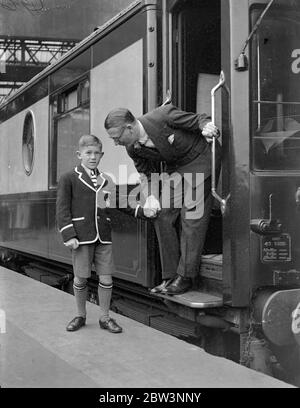 Henry Hall . 'RMS Queen Mary' Gastdirigent verlässt Waterloo auf dem Bootszug. Henry Hall , Leiter der BBC Dance Band, der Gastdirigent an Bord der "RMS Queen Mary" auf ihrer Jungfernfahrt sein soll, verließ Waterloo Station auf dem Bootstrian, um den Linienschiff in Southampton zu besteigen. Auf der Reise, Hall ist es, Konzerte nach England und Amerika zu übertragen. Foto zeigt, Henry Hall Bieten Abschied von seinem Sohn Michael in Waterloo. 27 Mai 1936 Stockfoto