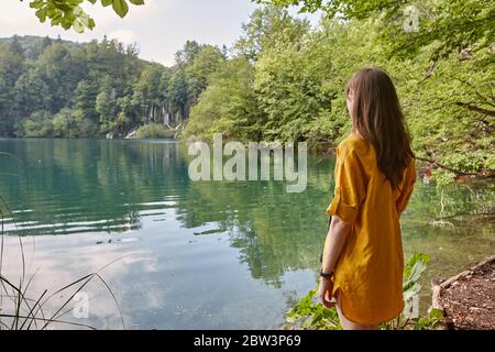 Frau mit Blick auf Wasserfälle und Seen im Nationalpark Plitvice, Kroatien Stockfoto