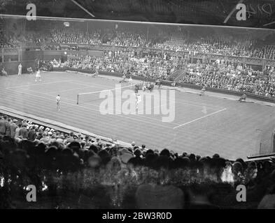 Kay Stammes und Helen Jacobs treffen sich im ersten Wightman Cup Spiel. Trotz der zweifelhaften Wetterbedingungen gab es in Wimbledon ein gutes Publikum, um das Eröffnungsspiel des Wightman Cup-Wettbewerbs zwischen Miss Kay Stammers (Großbritannien) und Miss Helen Jacobs (USA) zu sehen. Foto zeigt, eine allgemeine Ansicht des Spiels. Miss Stammers steht im Vordergrund. 12 Juni 1936 Stockfoto