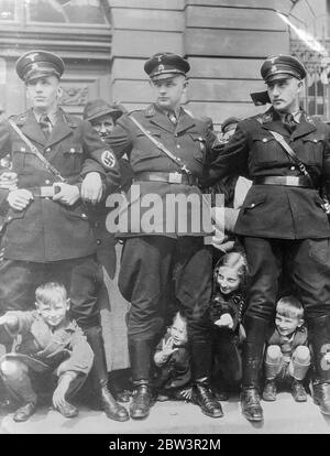 Ein Blick auf den Kanzler. Kinder, die zwischen die Beine von stämbernen SS-Männern späht ( Nazi-Schwarzgarden ), die Schulter an Schulter in den Berliner Straßen standen, als Kanzler Hitler durchkam, um seine Rede zum Nationalen Tag der Arbeit ( 1. Mai ) auf dem Lustgarten zu halten. Mai 1936 Stockfoto