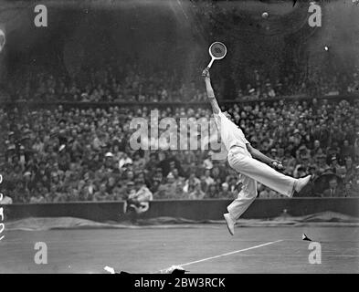 Fred Perry besiegt Quist in Davis Cup Singles Champion Fred Perry besiegte Adrian Quist aus Australien 6 - 1 ; 4 - 6 ; 7 - 5 ; 6 - 2 ; in den Singles der Davis Cup Challenge Runde zwischen England und Australien in Wimbledon . Foto zeigt : Perry springt für den Ball während des Spiels mit Quist . Juli 1936, 26 Stockfoto