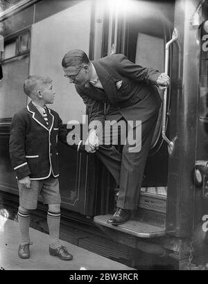 Henry Hall . 'RMS Queen Mary' Gastdirigent verlässt Waterloo auf dem Bootszug. Henry Hall , Leiter der BBC Dance Band, der Gastdirigent an Bord der "RMS Queen Mary" auf ihrer Jungfernfahrt sein soll, verließ Waterloo Station auf dem Bootstrian, um den Linienschiff in Southampton zu besteigen. Auf der Reise, Hall ist es, Konzerte nach England und Amerika zu übertragen. Foto zeigt, Henry Hall Bieten Abschied von seinem Sohn Michael in Waterloo. 27 Mai 1936 Stockfoto