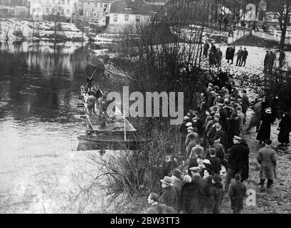 Floß bei der Flusssuche für Opfer der deutschen Eisenbahnunfall verwendet. Rettungskräfte suchen von einem Floß aus die Wasserwaten der Seale bei Groß Heringen , Thüringen , Deutschland , Für die Leichen der Opfer des katastrophalen Eisenbahnunfalls auf einer Brücke über den Fluss, die in den Verlust von 33 Menschenleben und Verletzungen an Dutzende von Menschen führte. Foto zeigt eine Menschenmenge, die die Suche nach der Saale bei Gross Heringen beobachtet. 28 Dezember 1935 Stockfoto