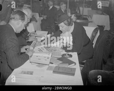 Mode an der Briefmarkenbörse. Experten aus aller Welt in London . Händler aus allen Teilen der Welt besuchen die neunte Börse der Londoner Briefmarkenhändler, die im Restaurant Holborn eröffnet wurde. Millionen von Briefmarken wechseln während der drei Tage der Börse, Preise werden in vielen Sprachen und Währungen genannt. Foto zeigt, modische Frau Goldberg von brüssel Blick auf Briefmarken. 27. April 1936 Stockfoto