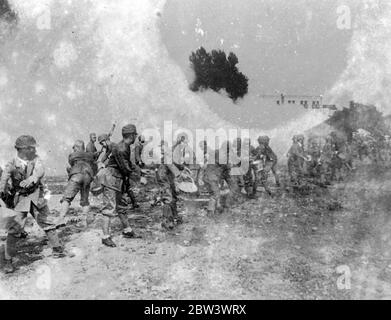 Herz von Japan als Air RAID ' Schlachtfeld realistische Luftangriffe in Manövern ' . Einige der realistischsten Luftangriffe, die je durchgeführt wurden, waren Teil der viertkombinierten Luftverteidigungsmanöver Tokyo, Yokohame, Kawasaki, um den Keihin-Bezirk im Herzen Japans gegen einen möglichen Angriff zu verteidigen. Foto zeigt, einige der 2, 500 Mitglieder der Keishikews Anti-Luftangriff-Verteidigungsgesellschaft erfolgreich Löschen Feuer angeblich durch eine feindliche Brandbombe auf dem ehemaligen Standort des Armeearsenals in Koishikawa verursacht. Bis 19. August 1936 Stockfoto