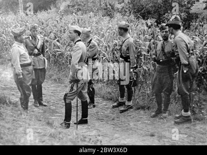 Italienische Krone Prinz bei Armee Manöver . Kronprinz Umberto und General Baistrocchi, der Untersekretär für Krieg, nehmen an den umfangreichen Manövern der italienischen Armee in Irpinia Teil. Foto zeigt, Kronprinz Umberto und General Federico Baistrocchi (zu seiner Rechten) im Gespräch mit Offizieren bei den Manövern. 24. August 1936 Original-Bildunterschrift von Negativ Stockfoto