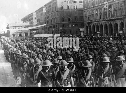 Mussolini begrüßt Truppen Rückkehr aus Abessinier Dienst . Hand erhoben in Gruß, Signor Mussolini begrüßte eine große Trennung von Sonne - helmeted italienischen Truppen, wie sie marschierten mit voller Ausrüstung durch die Piazza Venezia in Rom auf ihrer Rückkehr aus dem Dienst in Abessinien. Große Menschenmengen versammelten sich auf den Straßen, um die zurückkehrenden Bataillone zu begrüßen. Foto zeigt: Italienische Truppen, tragen Sonne - Helme und volle Ausrüstung, marschieren durch die Piazza Venezia in Rom auf ihrer Rückkehr aus Addis Abeba. 11. September 1936 Stockfoto