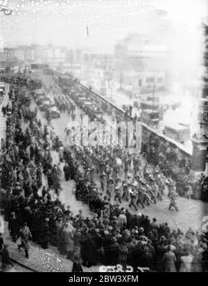 Mit ihren bekannten Schlapphüten, die erste Charge von australischen Truppen, die die australischen Dienste bei der Krönung vertreten, marschieren durch London von St. Pancras Station nach Wellington Barracks nach ihrer Ankunft des Boards, dass Oronsay . Foto zeigt: Eine allgemeine Ansicht, wie die Australier von der Garde-Band geführt St Pankreas verlassen durch die große Menschenmenge, die sie begrüßt. März 1937 Stockfoto