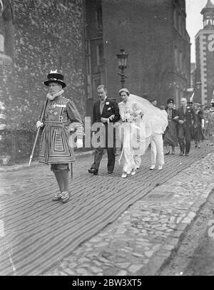 Tochter von Lord Milne heiratet am Turm. Der Hon, Joan Milne Tochter von Lord Milne, der Vollzugsbeamter des Tower of London, war mit Herrn JH Rutland in der historischen Kirche von St. Peter und Vincula im Turm verheiratet. Nach der Zeremonie ging die Braut und der Bräutigam über das Königshaus, das gegenüber der Kirche steht, zum Empfang. Das Haus, das in Heinrich VIII. Zeit für den Leutnant des Turms gebaut wurde, wird jetzt als Residenz für den Vollzugsbeamter gehalten. Foto zeigt, Chief Warder Smoker führt die Braut und Bräutigam zum König ' s Haus nach der Zeremonie. 1. März 16 Stockfoto