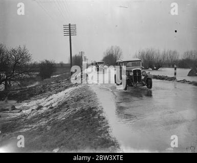 Defensive Überschwemmungen bedroht Bezirk .Main Cambridge Straße unter Wasser . Die schwerste Überschwemmungssituation seit Jahren ist die Fens , wo Tausende von Hektar Ackerland wurden von Flüssen überschwemmt, die ihre Ufer unter dem Druck von schweren Regenfällen und Frühjahrszeiten platzen . Zweihundertfünfzig Quadratmeilen Land sind von den Überschwemmungen bedroht. Foto zeigt, Hochwasser des Old West River, die seine Ufer platzen, Kaskadierung über die Hauptstraße Cambridge Ely in der Nähe von Stretham. 16 März 1937 Stockfoto