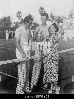 Ellsworth Vines sagt, dass er Fred Perry geschlagen hat. Ellsworth Vines, der amerikanische Tennisprofi, erhielt die Miami Beach Trophäe von Miss Terry Lawlor, Schauspielerin, nachdem er Fred Perry, den britischen Meister 5 - 7, 7 --5, 6 --4, in ihrem Spiel in Miami, Florida geschlagen hatte. Foto zeigt, Terry Lawlor Übergabe der Miami Beach Trophäe an Ellsworth Vines in Miami mit Fred Perry auf der linken Seite. 12 Februar 1937 Stockfoto