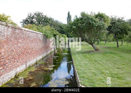 Reflexionen in einem Graben um einen ummauerten Garten in einem englischen Landhaus Stockfoto