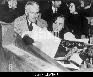 Charlie Chaplin und Paulette Goddard sehen "Jedermann". Charlie Chaplin und Paulette Goddard waren im Publikum im Hollywood Bowl, als Johannes Foulsen, Direktor des Dänischen Königlichen Theaters, "Everyman" inszenierte. Foto zeigt, Charlie Chaplin und Paulette Goddard studieren ihr Programm. 22. September 1936 Stockfoto