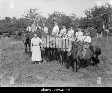 Reitunterricht für die Jungen an einer Surrey Schule. Training über Hürden und Hecken, Kinder von sechs Jahren und höher Wörter werden die Feinheiten der Reitkunst in den angenehmen Feldern der Surrey Landschaft in Upper Warlingham, in der Reitschule von Miss Margaret Case geführt gelehrt. Foto zeigt: Margaret Case mit einigen ihrer jungen Schüler während eines Unterrichts an der Surrey Schule. 17. September 1936 Stockfoto