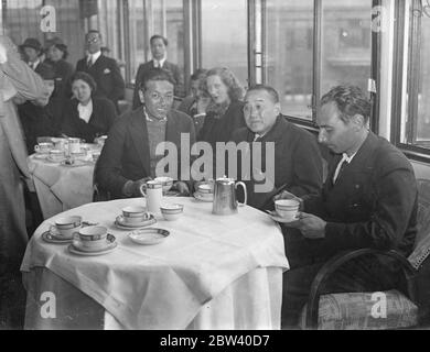 Rekordflieger aus Japan trinken nach 10,000 Meilen Flug Tee mit Ambassador. Fast die erste Aktion der japanischen Rekordflieger Masaaki Iinuma und Kenji Tsukakoshi, nachdem sie sich von den gastfreundlichen Menschenmassen in Croydon abgesetzt hatten, war, eine Tasse Tee im Aerodrome Hotel mit dem japanischen Botschafter, Herrn Shigeru Yoshida, zu trinken, der sie begrüßte. Der 27-jährige Masaaki Iinuma hatte seinen einplanen Göttlichen Wind [Kamikaze, ein Mitsubishi Ki-15 Karigane Flugzeug, Registrierung J-BAAI] in 94 Stunden über die 10,000 Meilen von Tokio nach London mit Krönungsgrüßen aus Japan geflogen. Fotoserien Stockfoto