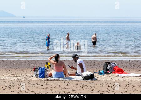 Troon, Großbritannien. Mai 2020. Da die lokalen Temperaturen auf mindestens Mitte 20 C steigen und mit der Entspannung der covid 19 Lockdown Maßnahmen, die Menschen wieder an den Strand zurückkehren. Zum Vergnügen, während versuchen, soziale Distanz zu halten. Kredit: Findlay/Alamy Live News Stockfoto