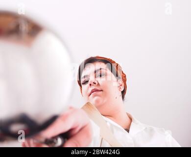 Kurvige Chefin bereitet Essen zu Stockfoto