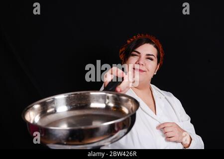 Kurvige Chefin bereitet Essen zu Stockfoto