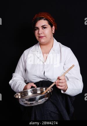 Kurvige Chefin bereitet Essen zu Stockfoto