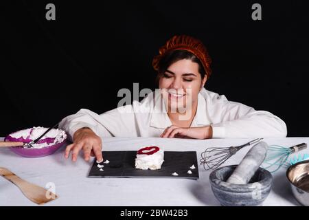 Schüler bereitet Gebäck in der schwarzen Hintergrund Stockfoto
