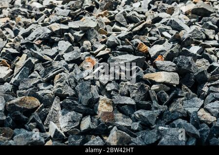 Grobe Steine, Schotter, Granitkies Nahaufnahme. Die raue Textur des Steins. Hintergrund des Baumaterials. Struktur Stockfoto