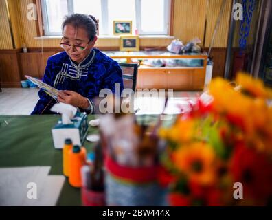 (200529) -- ALXA, 29. Mai 2020 (Xinhua) -- Taogerile stellt haarbestickte Thangka in Alxa linkes Banner, Nordchinas Autonome Region Innere Mongolei, 29. Mai 2020 her. Taogerile, 77, ist der führende Erben von Thangka mit Pferdehaarbestickung in der Autonomen Region der Inneren Mongolei. Sie sagte, dass sie die Verarbeitung von ihrem Großvater und ihrer Mutter geerbt habe. Taogerile ist besorgt über die sterbende Kultur und hat sich dem Erbe der traditionellen Kunstfertigkeit verschrieben. Die komplizierte Stickerei wurde als ein Programm zur Armutsbekämpfung in Alxa Left Banner bezeichnet. Bisher hat diese Verarbeitung direkt Stockfoto