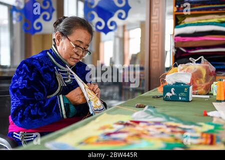 (200529) -- ALXA, 29. Mai 2020 (Xinhua) -- Taogerile stellt haarbestickte Thangka in Alxa linkes Banner, Nordchinas Autonome Region Innere Mongolei, 29. Mai 2020 her. Taogerile, 77, ist der führende Erben von Thangka mit Pferdehaarbestickung in der Autonomen Region der Inneren Mongolei. Sie sagte, dass sie die Verarbeitung von ihrem Großvater und ihrer Mutter geerbt habe. Taogerile ist besorgt über die sterbende Kultur und hat sich dem Erbe der traditionellen Kunstfertigkeit verschrieben. Die komplizierte Stickerei wurde als ein Programm zur Armutsbekämpfung in Alxa Left Banner bezeichnet. Bisher hat diese Verarbeitung direkt Stockfoto