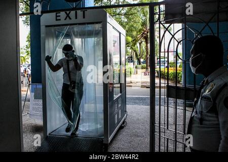 Manila. Mai 2020. Ein Militärreservist der philippinischen Armee durchläuft ein automatisches Desinfektionsmittel-Durchgangsystem während einer Simulation zur sozialen Distanzierung bei den Philippine National Railways (PNR) in Manila, Philippinen am 29. Mai 2020. Der philippinische Präsident Rodrigo Duterte hat am Donnerstag angekündigt, dass die Philippinen ab dem 1. Juni ihre Sperrbeschränkungen in Metro Manila weiter lockern werden, um mehr Unternehmen wieder zu eröffnen. Busse, Züge, Seeverkehr und Luftfahrt dürfen betrieben werden, sofern soziale Distanzen beobachtet werden. Quelle: Rouelle Umali/Xinhua/Alamy Live News Stockfoto