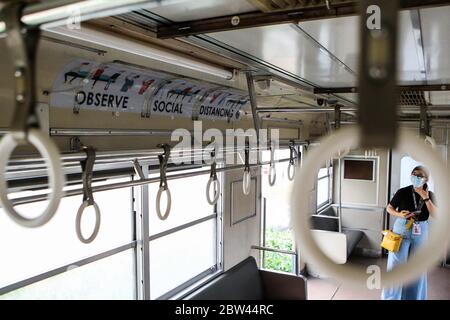 Manila. Mai 2020. Eine Frau schaut auf ein Schild in einem Zugwagen während einer sozialen Distanzierungssimulation bei den Philippine National Railways (PNR) in Manila, Philippinen am 29. Mai 2020. Der philippinische Präsident Rodrigo Duterte hat am Donnerstag angekündigt, dass die Philippinen ab dem 1. Juni ihre Sperrbeschränkungen in Metro Manila weiter lockern werden, um mehr Unternehmen wieder zu eröffnen. Busse, Züge, Seeverkehr und Luftfahrt dürfen betrieben werden, sofern soziale Distanzen beobachtet werden. Quelle: Rouelle Umali/Xinhua/Alamy Live News Stockfoto