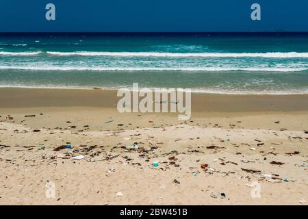 Plastikflaschen und anderer Müll, der auf die Sandküste geworfen wird, Müll am Meeresstrand, ökologisches Problem. Umweltverschmutzung. Schmutziger Sandstrände Stockfoto