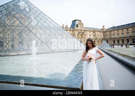 Braut in Hochzeitskleid in paris juli louvre. Stockfoto