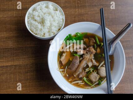 Draufsicht Fleisch chinesische klare Suppe und gedämpfter Reis auf einem braunen Holztisch. Stockfoto