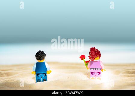 LEGO Minifiguren am Sandstrand. Zwei Erwachsene mit Schutzmaske haben Datum. Konzept der sozialen Distanzierung. Weichstellung. Lwiw, Stockfoto