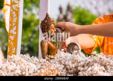 Während der Songkran Tage oder des traditionellen thailändischen Neujahrs gießen die Menschen Wasser über die Buddha Statuen. Stockfoto