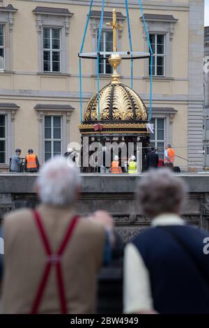 29. Mai 2020, Berlin: Zahlreiche Zuschauer beobachten beim Neubau des Berliner Schlosses, dem Humboldt Forum, wie die Kuppel mit dem Kreuz auf einem Sockel mit Engelsfiguren steht. Das ursprünglich ungeplante christliche Symbol auf dem Wiederaufbau des Palastes ist umstritten. Die erste Teileröffnung des Humboldt Forums, die für September geplant ist, wurde aus corona-Gründen verschoben. Das 644 Millionen Euro teure Gebäude soll jedoch noch in diesem Jahr eröffnet werden. Foto: Bernd von Jutrczenka/dpa Stockfoto