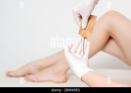 Hände der Frau unter Maniküre Werkzeuge aus Handwerk Umschlag vor Maniküre Verfahren. Stockfoto