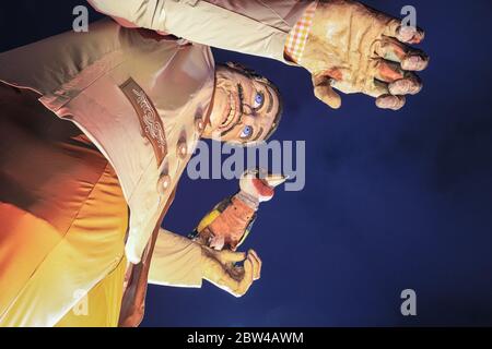 Eine riesige bayerische Männerfigur in traditioneller Lederhosen-Kleidung begrüßt die Besucher im Bavarian Village, Winter Wonderland, Hyde Park, London Stockfoto