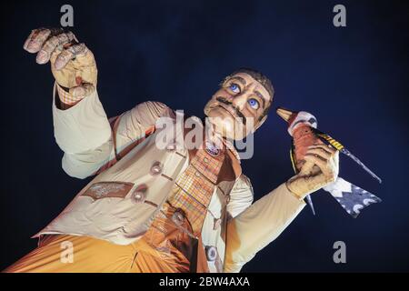 Eine riesige bayerische Männerfigur in traditioneller Lederhosen-Kleidung begrüßt die Besucher im Bavarian Village, Winter Wonderland, Hyde Park, London Stockfoto