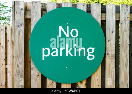 Nahaufnahme von grün No Parking Schild im Freien an Holzzaun in einem UK Morrison Supermarkt Parkplatz befestigt. Stockfoto