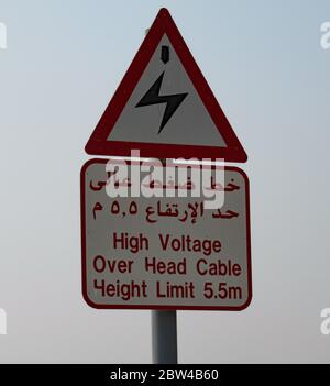 Melden Sie sich in der Wüste in Dubai Warnung vor Overhead-Strom funktioniert Stockfoto