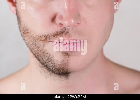Die untere Hälfte des Gesichts des Mannes ist nur Halbrasiert Stockfoto